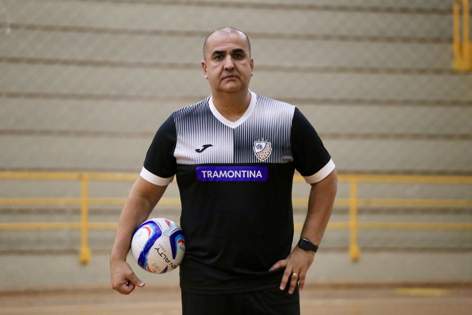 Professor Guaíba em quadra com uma bola de futsal